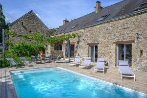 a patio with a pool and chairs and a house at VILLA CALYPSO - Longère avec piscine vue mer in Noyalo