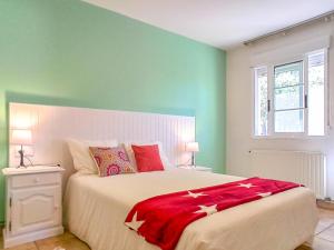 Un dormitorio con una cama con una manta roja encima. en A casa da panadeira, en Cambados
