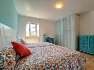 1 dormitorio con 1 cama grande con almohadas rojas en A casa da panadeira, en Cambados