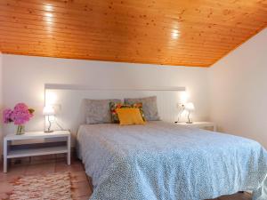 Un dormitorio con una cama con techo de madera. en A casa da panadeira, en Cambados