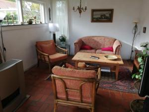 a living room with a couch and a table at Rustig gelegen vakantiebungalow in Kortgene