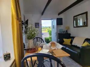 a baby sitting at a table in a living room at Idyllic cottage with private wood fire hot tub in Harrietsham