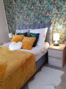 a bedroom with a bed with a floral wall at Apartament Meluzyna in Puck