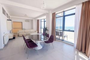 salon ze szklanym stołem i krzesłami w obiekcie Riviera Residence Apartments w Mamai
