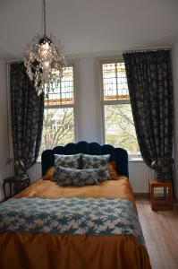 a bedroom with a bed and two windows at Huize Maurits in The Hague