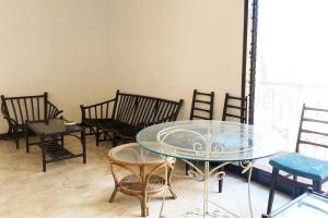 a room with chairs and a glass table and chairs at KoolKost near Universitas Wijaya Kusuma (Minimum Stay 30 Nights) in Dukuhkupang