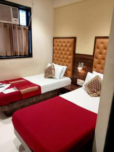 two beds in a room with red and white at Hotel New Silver Elite in Mumbai