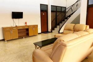 a living room with two couches and a television at KoolKost near Universitas Wijaya Kusuma (Minimum Stay 30 Nights) in Dukuhkupang