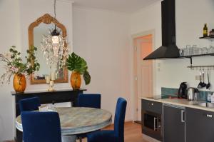 uma cozinha com uma mesa e algumas cadeiras azuis em Huize Maurits em Haia