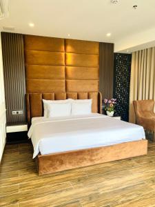 sypialnia z dużym łóżkiem z drewnianym zagłówkiem w obiekcie Mai Vy Hotel Tay Ninh w mieście Tây Ninh