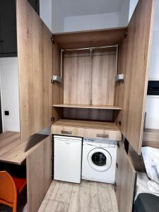 a washer and dryer in a small kitchen with wooden cabinets at Central Single Room Ground floor in Heraklio +4 photos