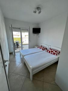 1 Schlafzimmer mit 2 Betten und einem Flachbild-TV in der Unterkunft Apartments Apartmani Bojana in Utjeha