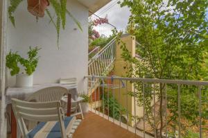balcón con mesa y sillas y escalera en Apartment Jasenka en Korčula
