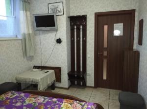 ein Schlafzimmer mit einem Bett und einem TV an der Wand in der Unterkunft Parasolka in Luzk