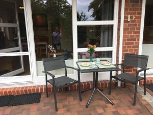 シェーンベルガー・シュトランドにあるOstsee-Entspannung, FeWo direkt am Meerのポーチ(テーブル、椅子付)