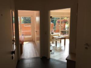 an open door to a room with a table and windows at Ostsee-Entspannung, FeWo direkt am Meer in Schönberger Strand