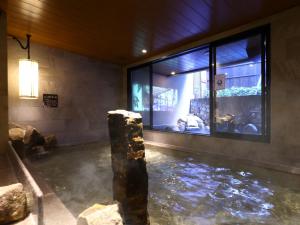 a room with a pool of water in front of a window at Dormy Inn Express Fujisan Gotemba in Gotemba
