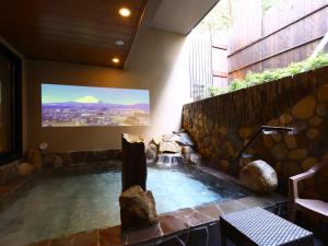 a hot tub with a tv in a building at Dormy Inn Express Fujisan Gotemba in Gotemba