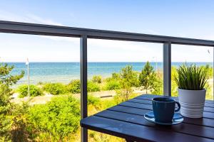 una mesa en un balcón con vistas al océano en VacationClub – Jantaris Apartament A24, en Mielno