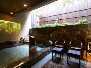 a room with two chairs and a pond at Dormy Inn Express Fujisan Gotemba in Gotemba