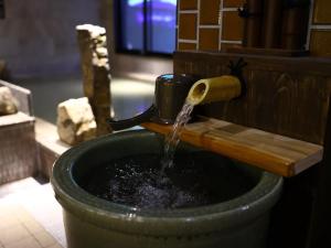 a water fountain in a bucket with water coming out at Dormy Inn Express Fujisan Gotemba in Gotemba