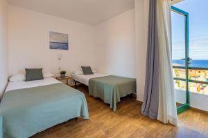 A bed or beds in a room at Apartamentos Los Rosales