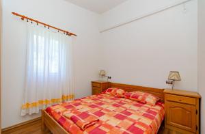 a bedroom with a bed with a checkered blanket at Apartments Oliver in Putniković