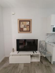 トレモリノスにあるLOS NIDOS CARIHUELA NEW&BEACHの白いリビングルーム(テレビ、椅子付)