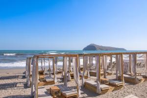 szereg leżaków na plaży w obiekcie Τhe Noverian Antama Organic Beach Resort Chania w mieście Agia Marina Nea Kydonias