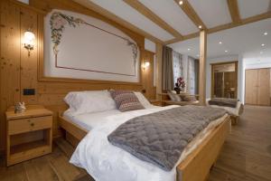 ein Schlafzimmer mit einem großen Bett in einem Zimmer in der Unterkunft Albergo Miravalle Fai della Paganella in Fai della Paganella
