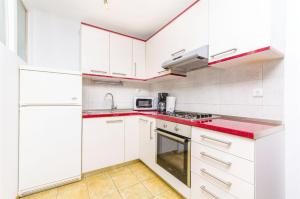 a kitchen with white cabinets and red counter tops at Apartments Dragica in Slatine +40 photos
