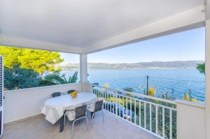 a balcony with a table and chairs and a view of the water at Apartments Dragica in Slatine