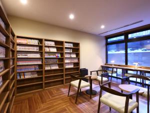 a library with book shelves and tables and chairs at Dormy Inn Express Fujisan Gotemba in Gotemba