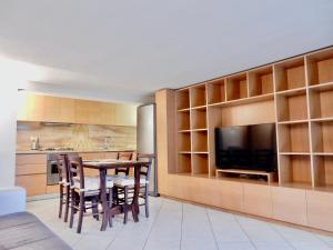 una cucina e una sala da pranzo con tavolo e TV di Sole apartment a Lido di Camaiore
