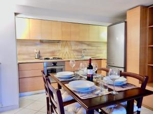 cocina con mesa de madera y copas de vino en Sole apartment, en Lido di Camaiore