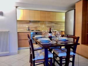een keuken met een houten tafel met wijnglazen bij Sole apartment in Lido di Camaiore