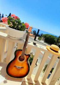 una guitarra sentada en un banco blanco junto a una mesa en Rooms Villa Gala, en Mlini