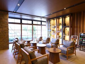 a waiting room with chairs and tables and windows at Dormy Inn Express Fujisan Gotemba in Gotemba