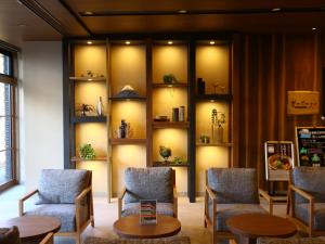 a room with chairs and tables and shelves with plants at Dormy Inn Express Fujisan Gotemba in Gotemba