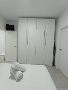 een witte kamer met een bed en witte kasten bij FUENGIROLA SWEET & BEACH in Fuengirola