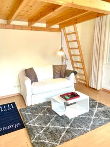 a living room with a white couch and a ladder at Executive Apartement Gastein in Bad Gastein