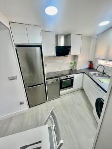 a kitchen with white cabinets and stainless steel appliances at CASA SIMÓN in Albarracín +9 photos