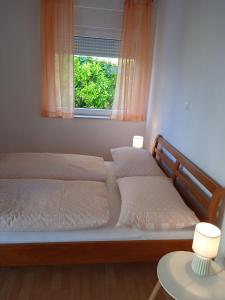 two beds in a bedroom with a window at Apartments Blazenka in Trogir