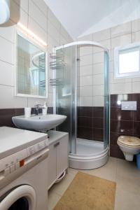 ein Bad mit einer Dusche, einem Waschbecken und einem WC in der Unterkunft Apartment Krekovic in Pag