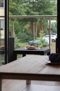 une table avec deux verres et une assiette de nourriture dans l'établissement Little Laguna Apartments SPA & Gym by Noclegi Renters, à Międzywodzie