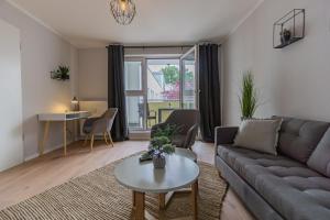 ein Wohnzimmer mit einem Sofa und einem Tisch in der Unterkunft Spreewald-Apartment, 75qm, 2 Schlafzimmer, Tiefgarage, Balkon, Netflix, Waschtrockner in Cottbus