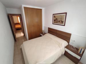mała sypialnia z łóżkiem i lustrem w obiekcie Apartamento LAIA w mieście Oropesa del Mar +16 zdjęć