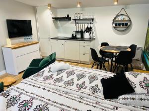 1 dormitorio con 1 cama y 1 mesa con sillas en WRZOS resort & wellness **** DOMKI CAŁOROCZNE, en Węgierska Górka
