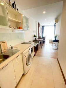 - une cuisine avec lave-linge et sèche-linge dans la chambre dans l'établissement The Astra Suites Condo, à Chiang Mai