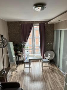 uma sala de estar com uma mesa e cadeiras e uma janela em Centrum Apartament em Gdansk